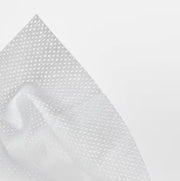 Close-up of white fabric with a subtle pattern on a light gray background